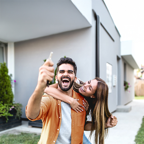 Excited couple holding keys, just bought a new house Excited couple holding keys, just bought a new house