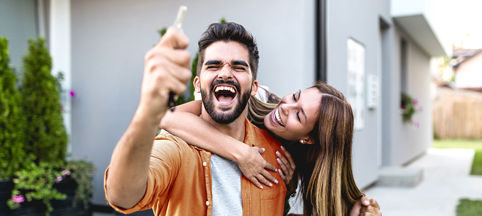 Excited couple holding keys, just bought a new house Excited couple holding keys, just bought a new house