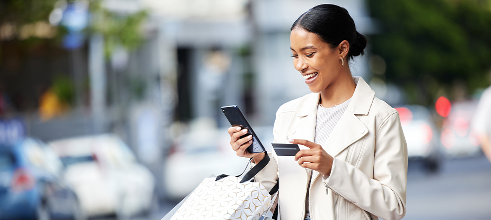 Young woman with mobile phone and bank card